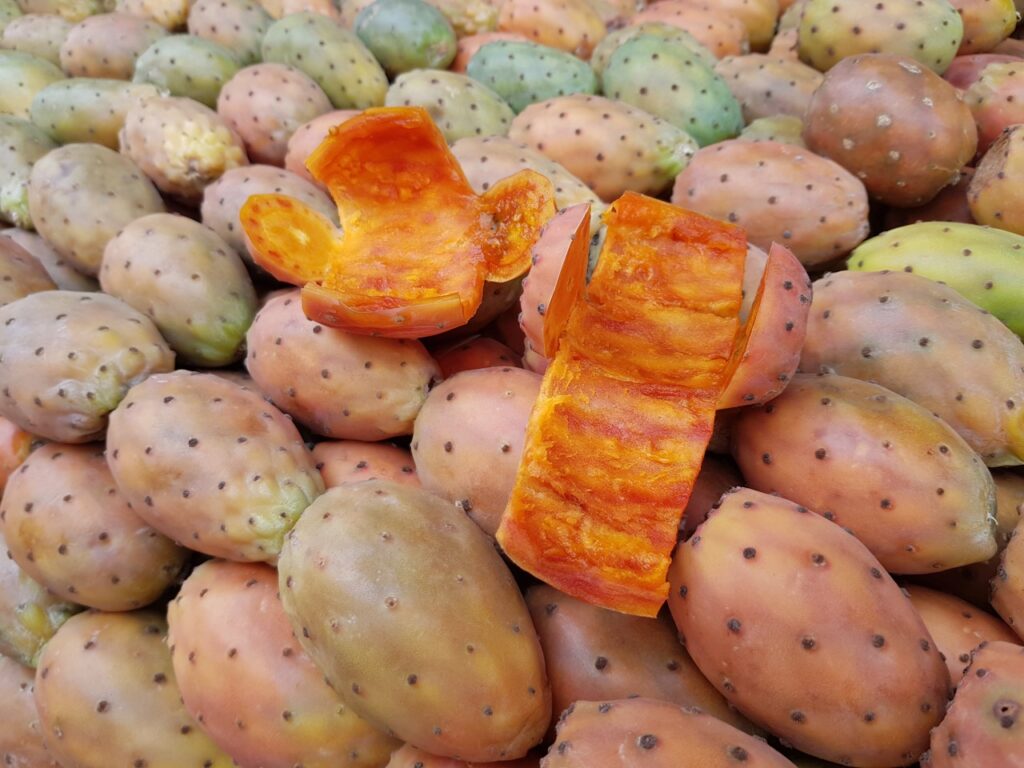 Cactus (prickly pear) fruit for sale. Remnants of peeled fruit in the middle.